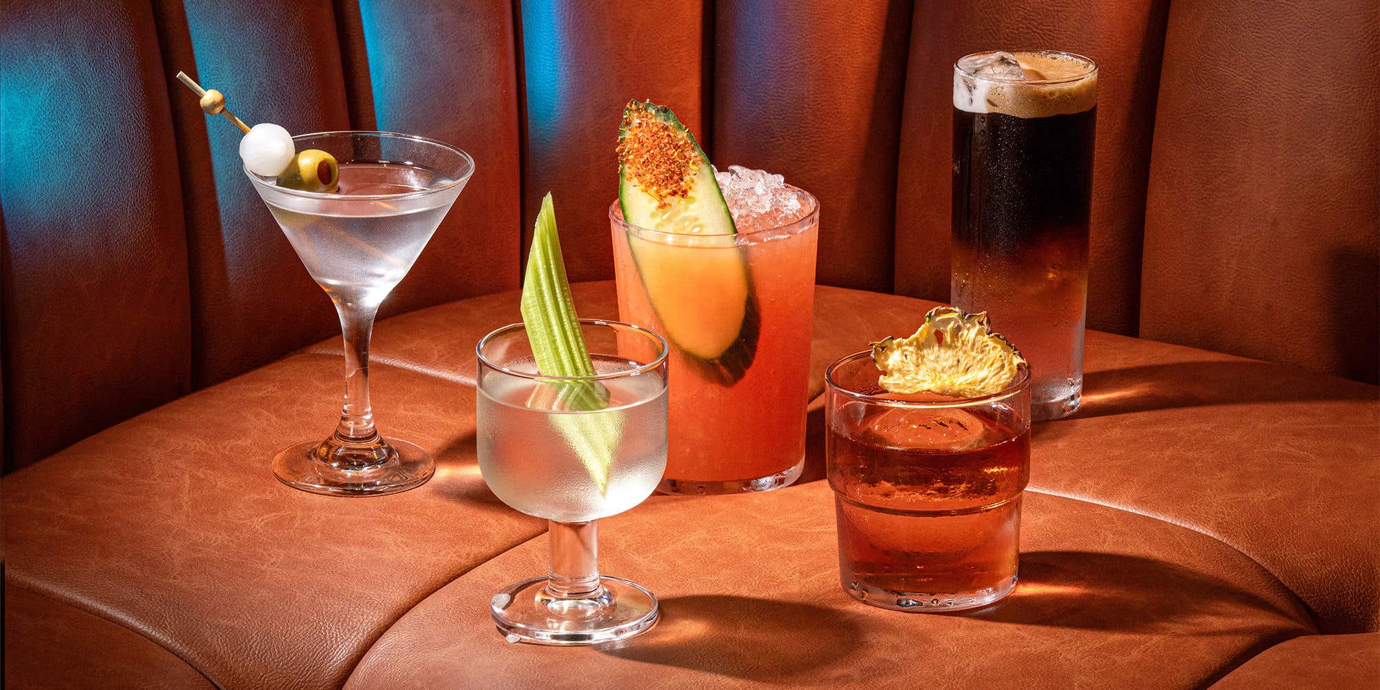 5 different cocktails on a brown sofa. 