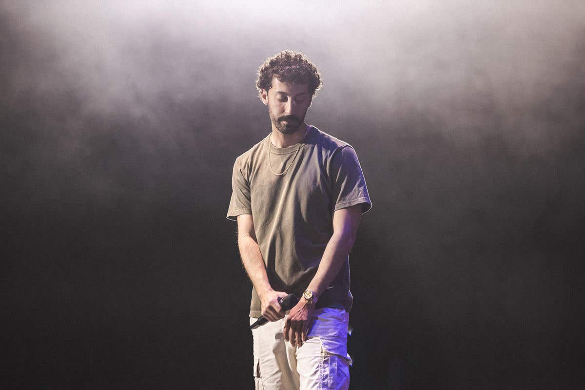 Comedian Morgan Jay on a smoky stage holding a microphone.